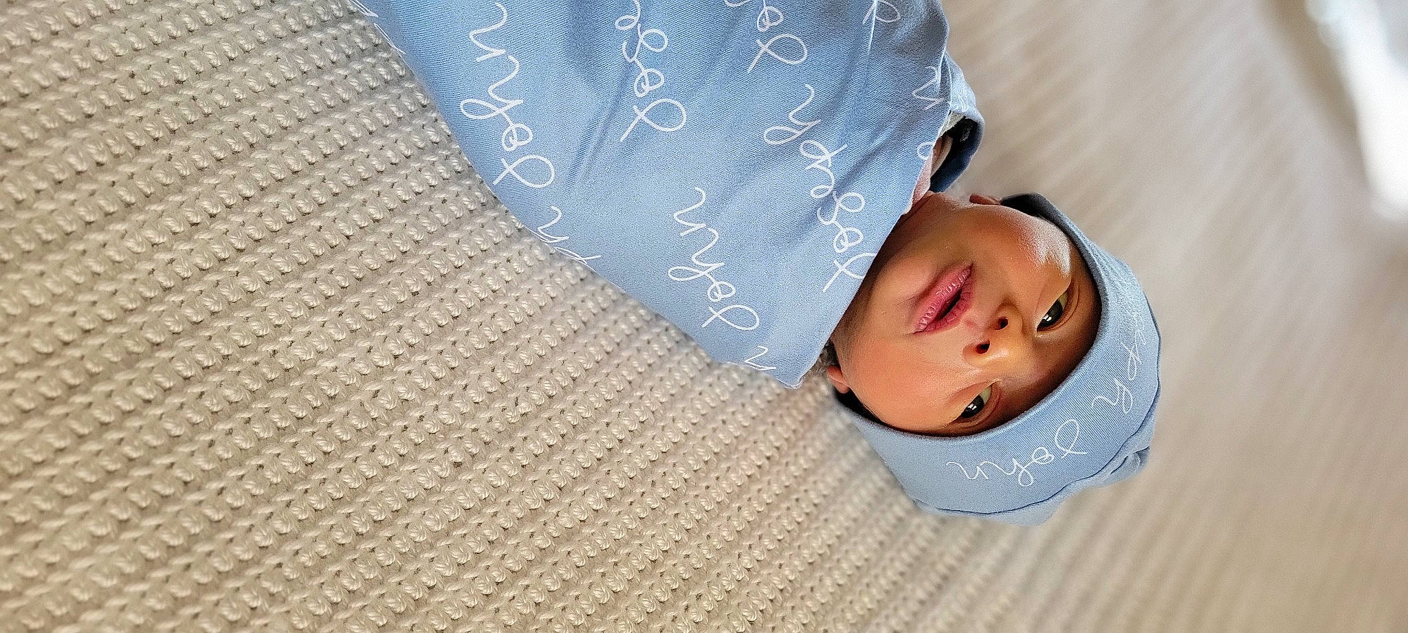 Joseph is registered to the contest to win money with this photo: baby, baby_toddler_clothing, child, comfort, drinkware, eyelash, fashion_accessory, finger, flooring, font, handwriting, happy, headwear, linens, pattern, person, rectangle, skin, sleeve, textile