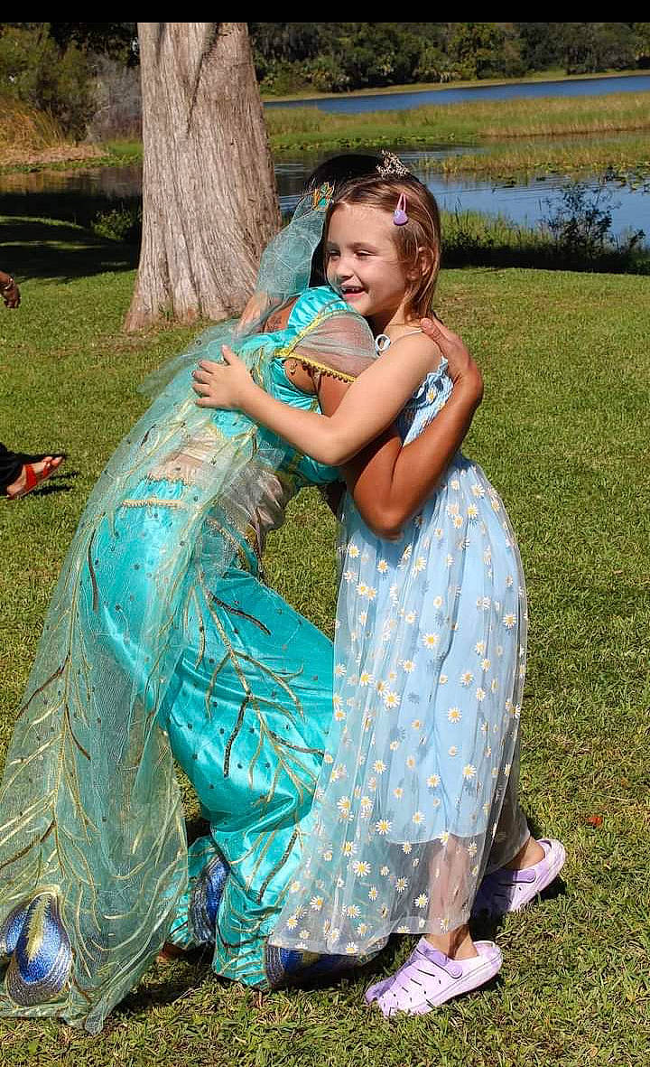 Brooke joined the competition — help win amazing prizes! azure, botany, event, formal_wear, fun, garden, grass, grassland, green, happy, joy, lawn, leisure, people_in_nature, person, plant, recreation, sandal, sitting, smile