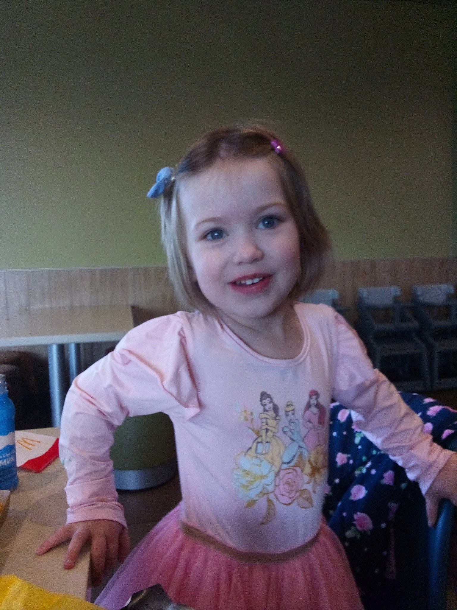 Lydia is registered to the contest to win money with this photo: baby_toddler_clothing, ballet_tutu, chair, child, event, face, fun, hairstyle, happy, iris, joy, magenta, person, plastic_bottle, room, sitting, sleeve, smile, standing, t_shirt