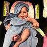 baby, blanket, blue_blanket, infant, smiling, face, feet, hand, seat, cushion, warning_label, towel, cozy, cute, child, wrapped, indoors, comfort, happy, portrait