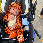 Dylan joined the competition — help win amazing prizes! baby, blanket, car_seat, child, concrete, cute, footwear, graco, happy, hood, infant, orange_clothing, outdoor, person, safety, seat, smiling, tiger_onesie, toddler, toy