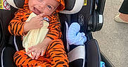 Dylan joined the competition — help win amazing prizes! baby, blanket, car_seat, child, concrete, cute, footwear, graco, happy, hood, infant, orange_clothing, outdoor, person, safety, seat, smiling, tiger_onesie, toddler, toy