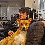 Idunn a rejoint le concours — aidez-le/la à gagner de superbes lots ! dog, person, couch, indoor, living_room, smile, casual_clothing, curly_hair, furniture, window, blanket, table, bottle, photography, home_decor, relaxing, pet, friendly, portrait, domestic_life