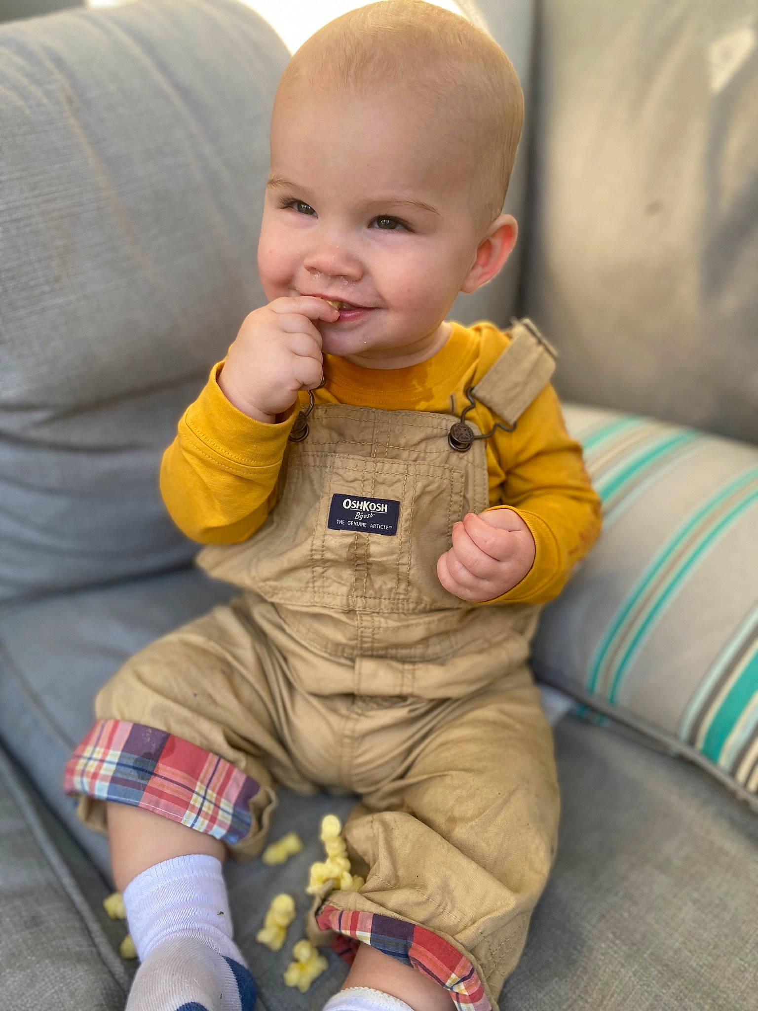 Colt is registered to the contest to win money with this photo: baby, baby_toddler_clothing, cheek, child, chin, comfort, eye, face, finger, fun, head, human_body, orange, outerwear, person, sitting, skin, sleeve, smile, standing