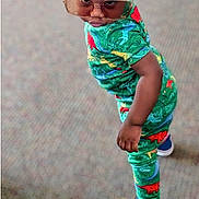 Nico joined the competition — help win amazing prizes! toddler, child, sunglasses, green_clothing, dinosaur_pattern, slippers, standing, carpet, playful, confident, indoor, footwear, colorful, person, casual, cute, fashion, attitude, young_child, portrait