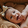 baby, infant, bow, headband, blanket, knitted, smile, happy, cute, child, fingers, mouth, skin, portrait, closeup, lying_down, cozy, warm, soft, expression