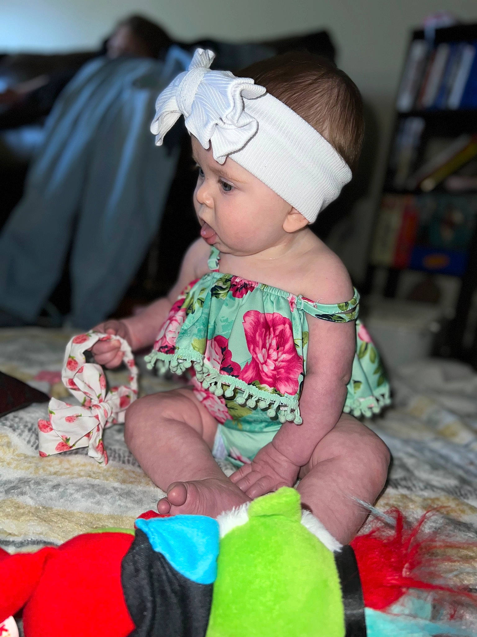 Harleigh is registered to the contest to win money with this photo: baby, baby_toddler_clothing, bookcase, cap, child, event, fashion_accessory, fun, grass, happy, headgear, headpiece, headwear, magenta, pattern, person, pink, shelf, sitting, skin