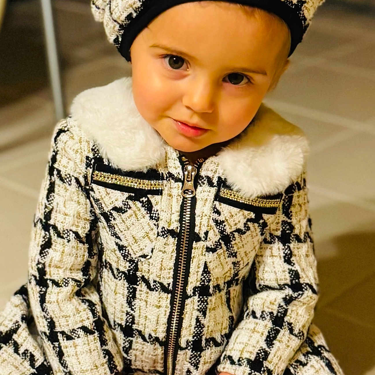 Evelisse joined the competition — help win amazing prizes! beanie, bonnet, cap, clothing, coat, doll, face, fashion, fur, hat, head, hoodie, jacket, lady, person, photography, portrait, sitting, sleeve, toy