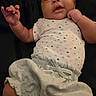 Zaylee is registered to the contest to win money with this photo: baby, infant, child, onesie, clothing, shorts, star_pattern, looking_up, portrait, cute, skin, hand, face, expression, lying_down, person, young, soft_lighting, indoors, background