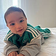 Kenan a rejoint le concours — aidez-le/la à gagner de superbes lots ! baby, child, infant, bed, blanket, clothing, green, gray, smile, face, hands, eyes, hair, indoor, light, window, curtains, soft_light, portrait, cute