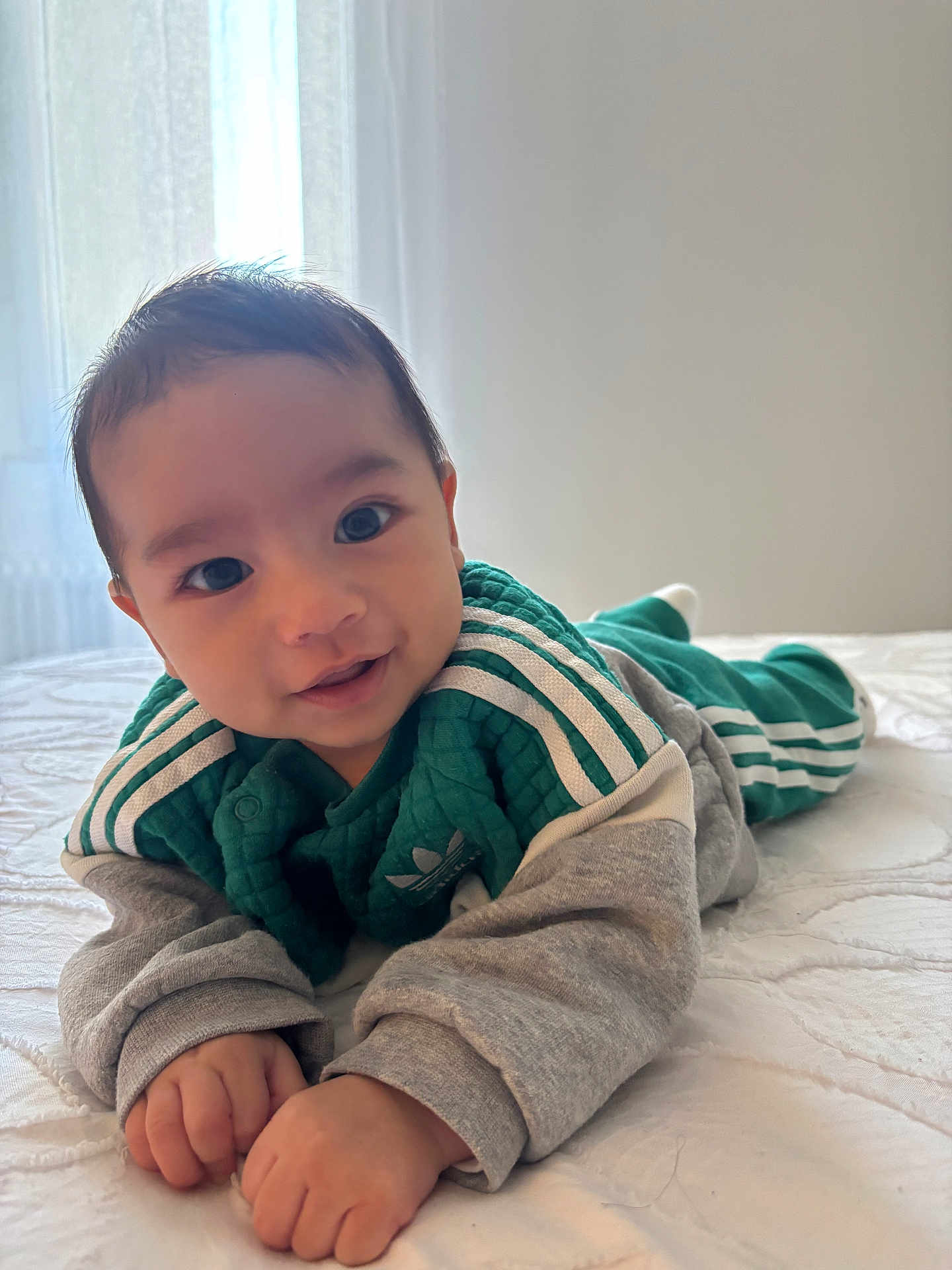 Kenan a rejoint le concours — aidez-le/la à gagner de superbes lots ! baby, child, infant, bed, blanket, clothing, green, gray, smile, face, hands, eyes, hair, indoor, light, window, curtains, soft_light, portrait, cute