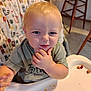 Riot joined the competition — help win amazing prizes! baby, blond_hair, chair, child, clothing, cute, expression, face, food, hand, high_chair, indoor, kitchen, messy, mischievous, person, seat, table, thinking, toddler