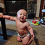 baby, child, diaper, indoor, carpet, table, furniture, toy, play, kneeling, smiling, happy, face, skin, room, home, person, infant, cute, young