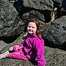 Rubie Jean is registered to the contest to win money with this photo: blue_sky, casual_clothing, child, daylight, hair, happy, nature, outdoor, patterned_leggings, person, pink_jacket, portrait, relaxing, rocks, scenery, shoes, sitting, smile, sunny, young