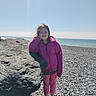 Rubie Jean is registered to the contest to win money with this photo: beach, casual, child, coast, girl, jacket, leggings, leisure, nature, ocean, outdoor, pebble, pink, rock, shoes, sky, smile, standing, sunlight, wind