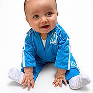 Manaël participe au concours pour gagner de l'argent avec cette photo : baby, infant, child, smile, blue_tracksuit, sitting, white_background, socks, hands, eyes, portrait, adorable, hair, crawling_pose, looking_up, cute, happy, studio_shot, clothing, footwear