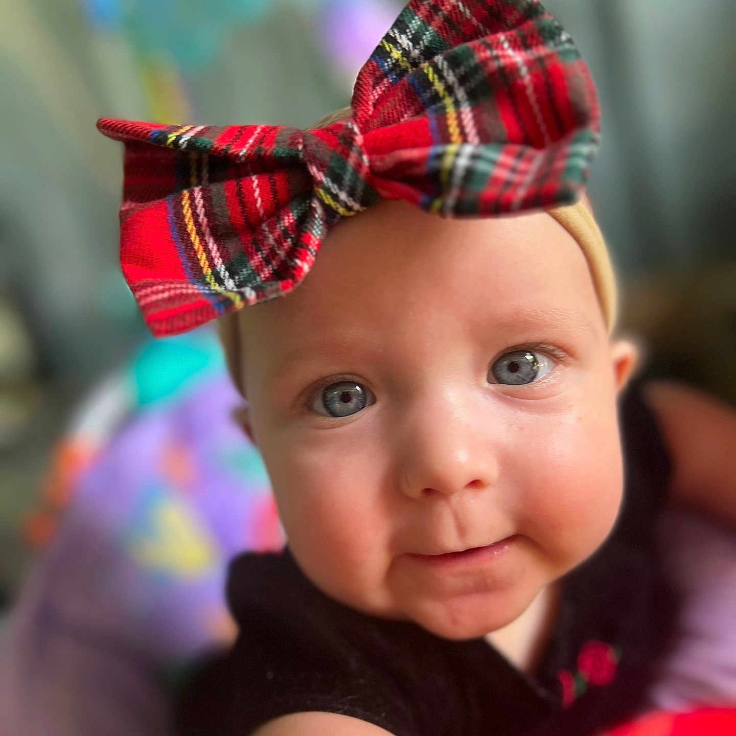Layla is registered to the contest to win money with this photo: adorable, baby, black_shirt, blue_eyes, bow, child, close_up, clothing, curious, cute, expression, face, headband, indoor, infant, person, portrait, reaching_out, skin, soft_focus