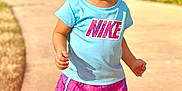 Nova is registered to the contest to win money with this photo: blue_shirt, casual, child, clothing, curly_hair, cute, daytime, expression, nike, outdoor, person, residential_area, shadow, shorts, sidewalk, summer, sunlight, toddler, walking, young_child