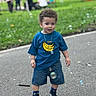 Noah is registered to the contest to win money with this photo: child, toddler, boy, portrait, outdoor, park, grass, pavement, bubbles, smiling, standing, blue_shirt, banana_shirt, denim_shorts, sneakers, curly_hair, necklace, bracelet, people, daylight