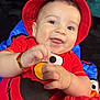 baby, child, smiling, red_hat, elmo_shirt, plush_toy, happy, cute, portrait, indoor, closeup, face, hands, infant, red_clothing, playing, fun, joy, bright_colors, soft_toy