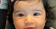 Angelina joined the competition — help win amazing prizes! baby, infant, child, car_seat, seatbelt, harness, portrait, face, wide_eyes, looking_at_camera, indoors, vehicle, passenger, pink_clothing, hair_bow, dark_hair, sitting, close_up, safety_label, photography