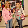 Lola is registered to the contest to win money with this photo: child, woman, people, holiday, christmas, decorations, classroom, smiling, festive, indoor, casual_clothing, jeans, sweater, boots, wall, floor, group, portrait, celebration, event