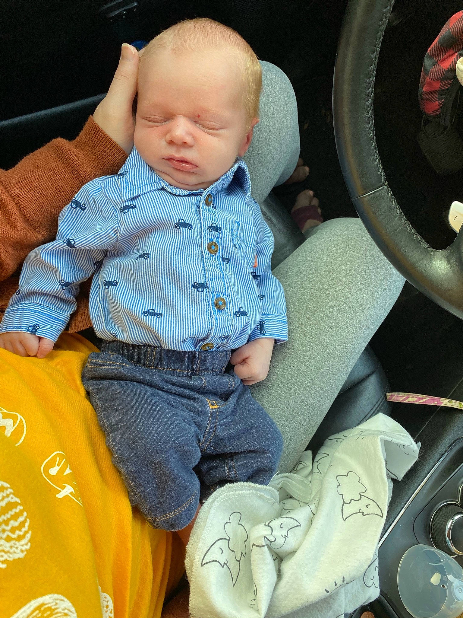 Shepherd is registered to the contest to win money with this photo: auto_part, automotive_tire, baby, baby_products, baby_toddler_clothing, car_seat, chair, child, comfort, electric_blue, lap, leg, pattern, person, product, sitting, sleeve, sneakers, steering_wheel, t_shirt