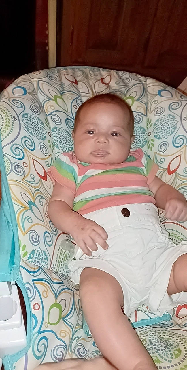 Aria is registered to the contest to win money with this photo: baby, baby_toddler_clothing, cheek, child, chin, comfort, eye, face, hairstyle, head, human_body, iris, linens, lip, person, product, skin, sleeve, smile, textile