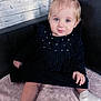 toddler, child, blue_eyes, pony_tail, velvet_dress, black_clothing, pink_blanket, soft_texture, indoor, couch, black_couch, curly_hair, cute, baby_socks, small_hand, face, portrait, sitting, young_child, light_skin