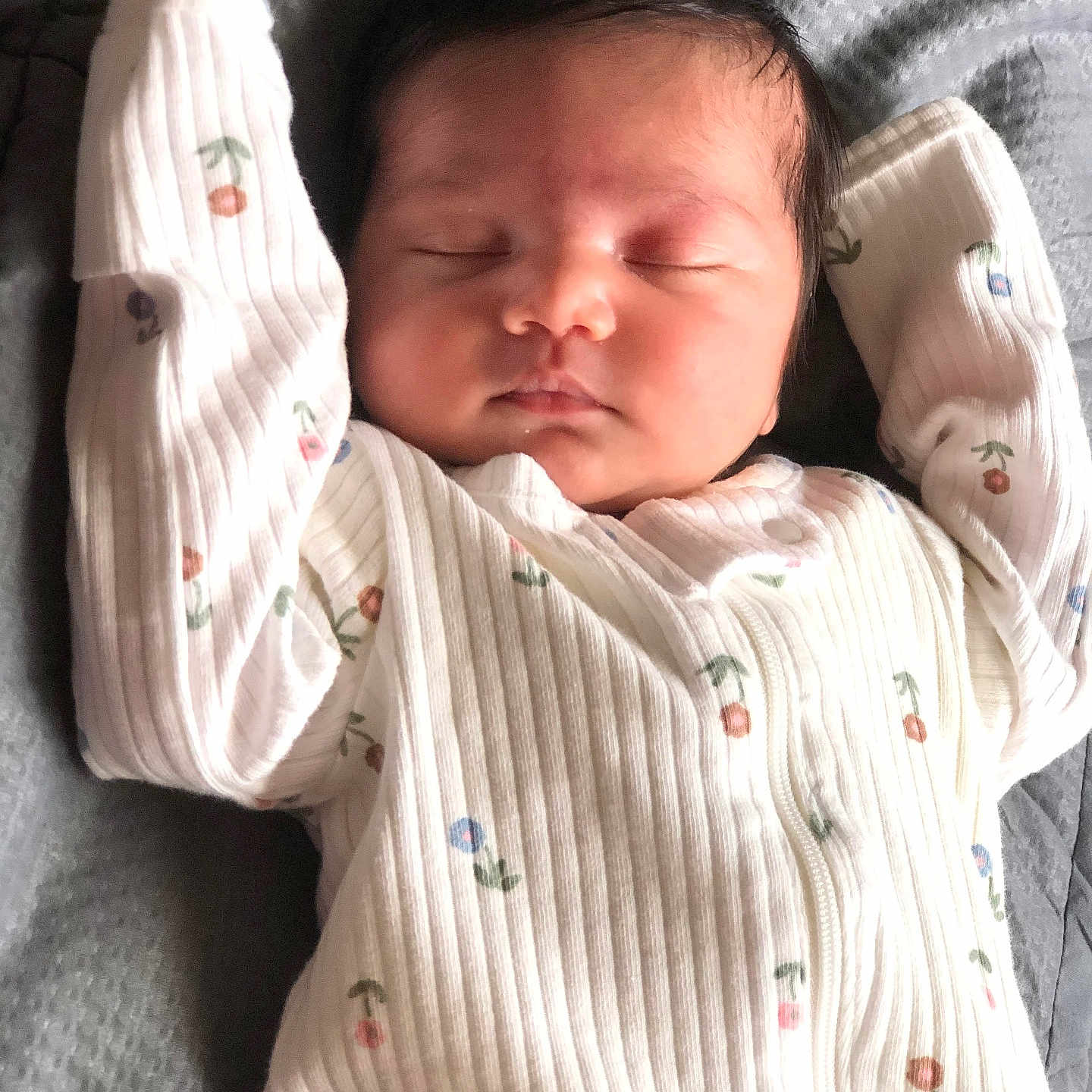 Sahana is registered to the contest to win money with this photo: arms_up, baby, child, closed_eyes, cozy, cute, face, floral_print, gray_background, head, infant, newborn, onesie, peaceful, portrait, resting, skin, sleeping, soft_light, texture