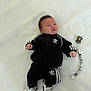 baby, infant, clothing, tracksuit, adidas, black, white, pacifier, beads, blanket, lying_down, footwear, cute, soft, indoors, child, person, small, young, portrait