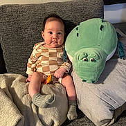 Leilee joined the competition — help win amazing prizes! baby, infant, plush_toy, stuffed_animal, couch, blanket, pacifier, socks, onesie, checkered_pattern, cute, face, eyes, sitting, pillow, upholstery, home_interior, soft_toy, cozy, smile