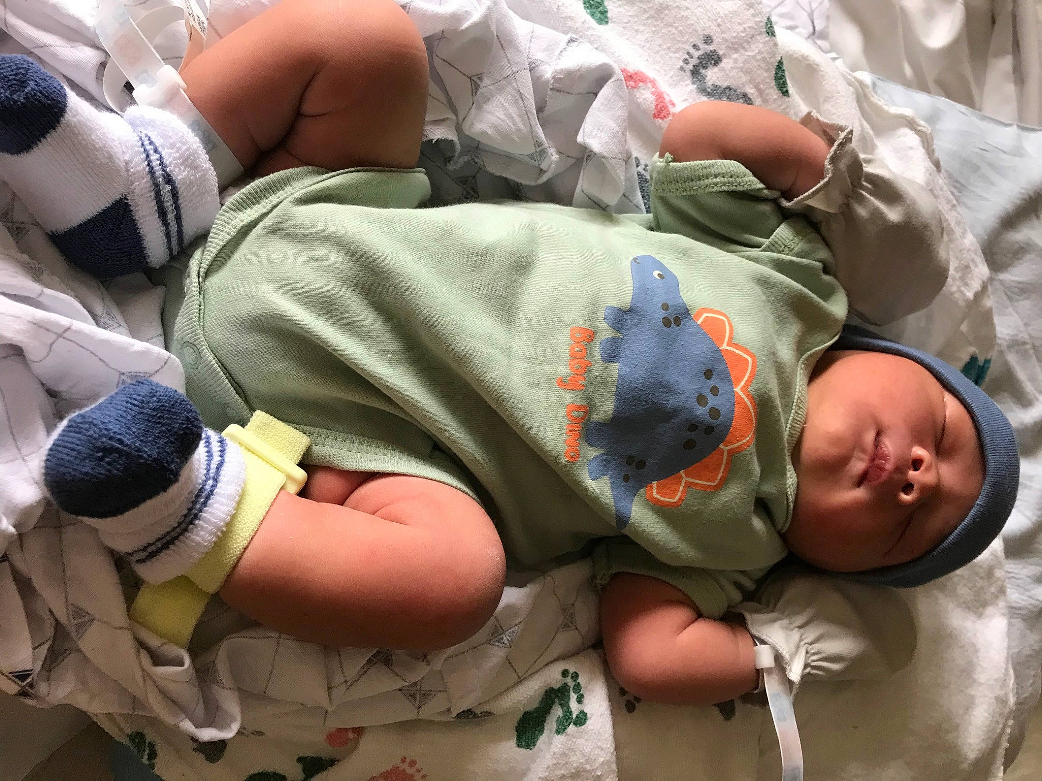 Kacey is registered to the contest to win money with this photo: abdomen, baby, baby_toddler_clothing, child, comfort, elbow, hand, headwear, human, human_body, human_leg, joint, knee, linens, mouth, nap, person, sitting, t_shirt, textile