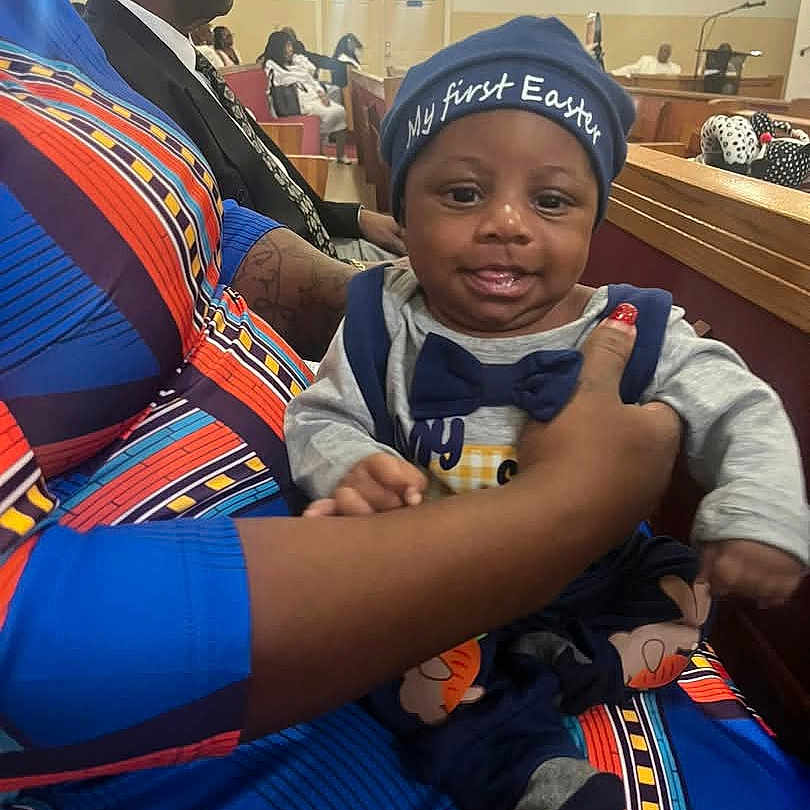 Emorii joined the competition — help win amazing prizes! baby, child, infant, easter, hat, bowtie, adult_hand, colorful_clothing, church, pew, man, suit, tie, glasses, people, seated, indoor, portrait, smiling, celebration