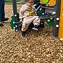Noam participe au concours pour gagner de l'argent avec cette photo : adult, casual, child, clothing, daytime, face, glasses, grass, green, outdoor, park, person, play_equipment, playground, shoe, slide, toddler, tree, wood_chips, yellow