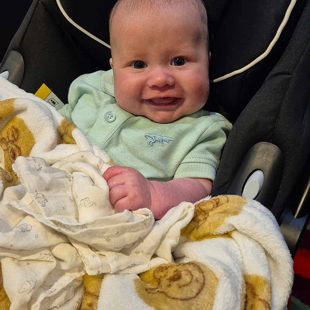 Rio is registered to the contest to win money with this photo: baby, bed, blanket, car, crib, cushion, face, furniture, happy, head, homedecor, infantbed, newborn, person, photography, portrait, quilt, smile, stroller, towel