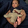 toddler, child, toy, teddy_bear, blanket, indoor, feet, clothing, person, bedroom, comfort, relaxation, cute, infant, soft_toy, portrait, young_child, lying_down, casual, home