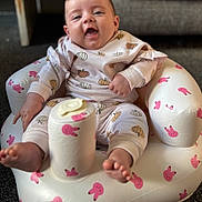 Harley joined the competition — help win amazing prizes! baby, carpet, child, clothing, comfortable, cozy, cute, face, happy, indoor, infant, inflatable_chair, pajamas, person, pink_bunny, playful, pumpkin_pattern, sitting, smiling, toes