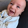 Gaspard participe au concours pour gagner de l'argent avec cette photo : baby, infant, smile, laughing, close_up, face, eyes, cheeks, mouth_open, onesie, newborn, portrait, couch, pillow, skin, indoor, eyelashes, happy, hand, fabric