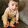 baby, barefoot, brown_couch, casual_clothing, child, couch, cozy, curious, cute, dinosaur_pants, expression, footwear_free, home, indoors, infant, portrait, sitting, small_hands, striped_shirt, young