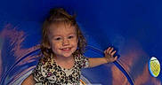 Kyleigh is registered to the contest to win money with this photo: child, toddler, smiling, curly_hair, blue_tunnel, playground, patterned_shirt, happy, face, outdoor, play, person, cute, young_child, fun, daylight, joy, expression, clothing, leisure