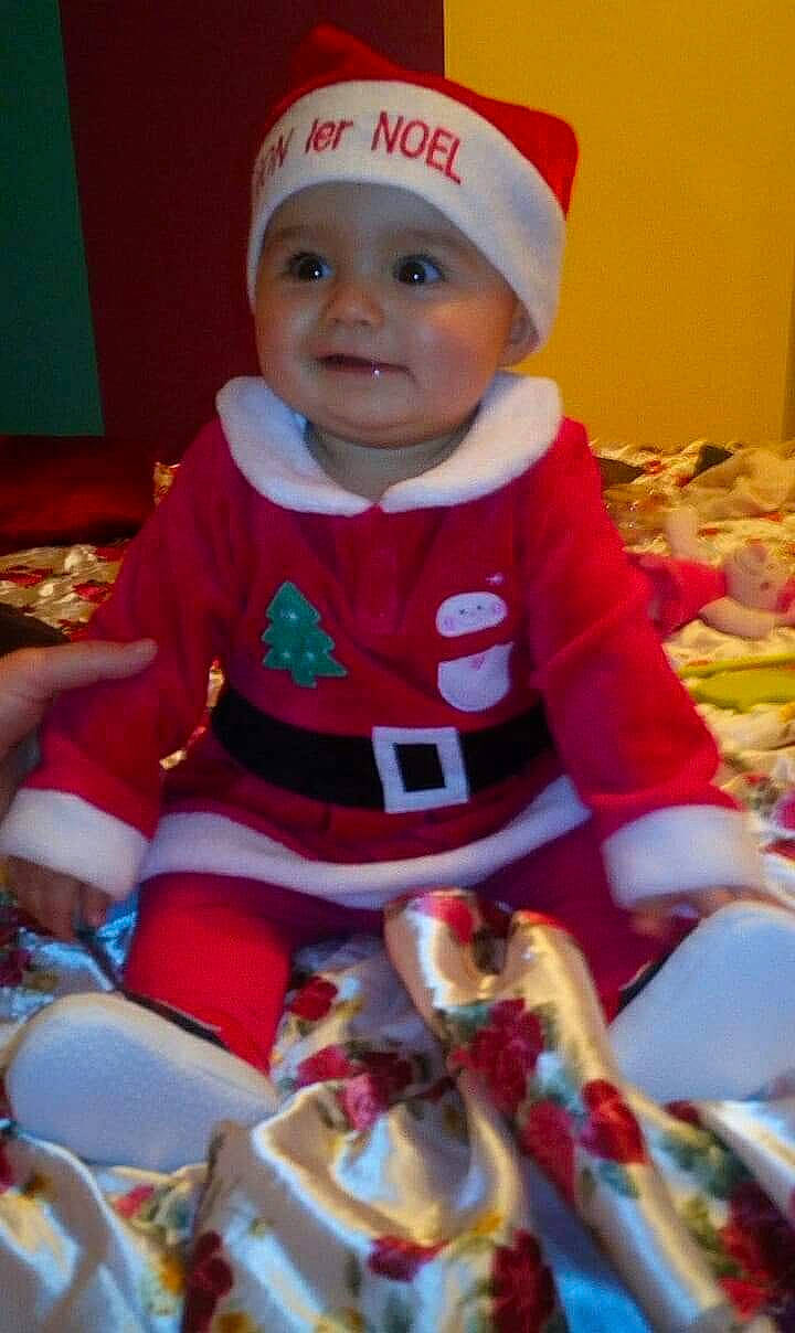 Louna participe au concours pour gagner de l'argent avec cette photo : baby, baby_toddler_clothing, bonnet, cheek, child, christmas, christmas_eve, costume, costume_accessory, costume_hat, fictional_character, headwear, lap, nose, person, toddler