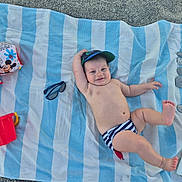 Matthew participe au concours pour gagner de l'argent avec cette photo : baby, towel, beach, sunglasses, bucket, sunscreen, stones, number_5, striped_diaper, cap, floaties, mickey_mouse, sand, smiling, child, sun_protection, outdoor, play, relaxing, summer