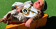 Rhett joined the competition — help win amazing prizes! newborn, baby, infant, sleeping, portrait, outdoor, grass, sunlight, hat, cap, sports_theme, medallion, necklace, beads, onesie, clothing, socks, orange_box, seated, face