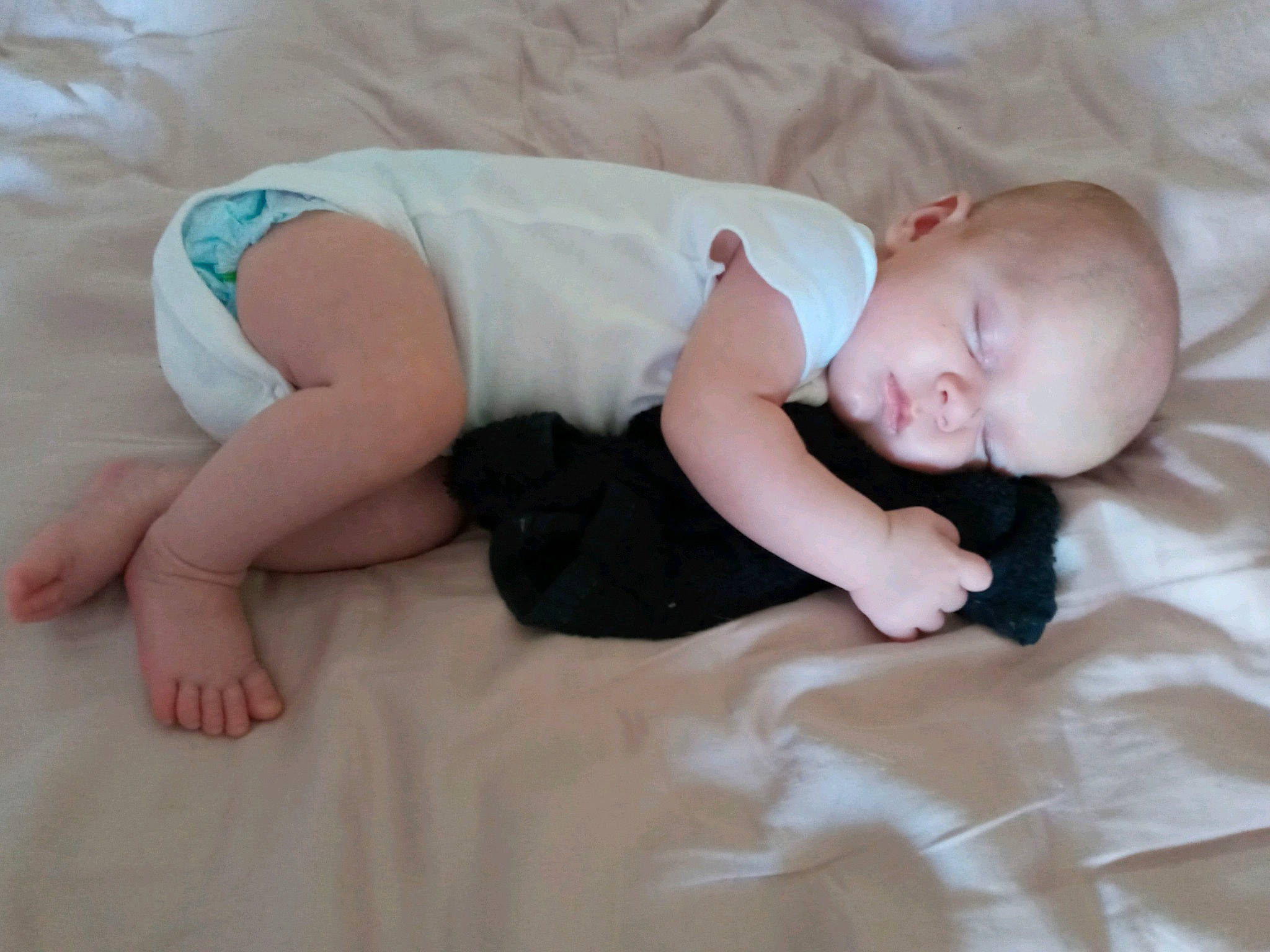 Johnathon is registered to the contest to win money with this photo: baby, baby_toddler_clothing, bedtime, child, comfort, finger, flooring, foot, fun, grass, hand, human_leg, linens, pattern, person, room, sitting, skin, sleeve, sock