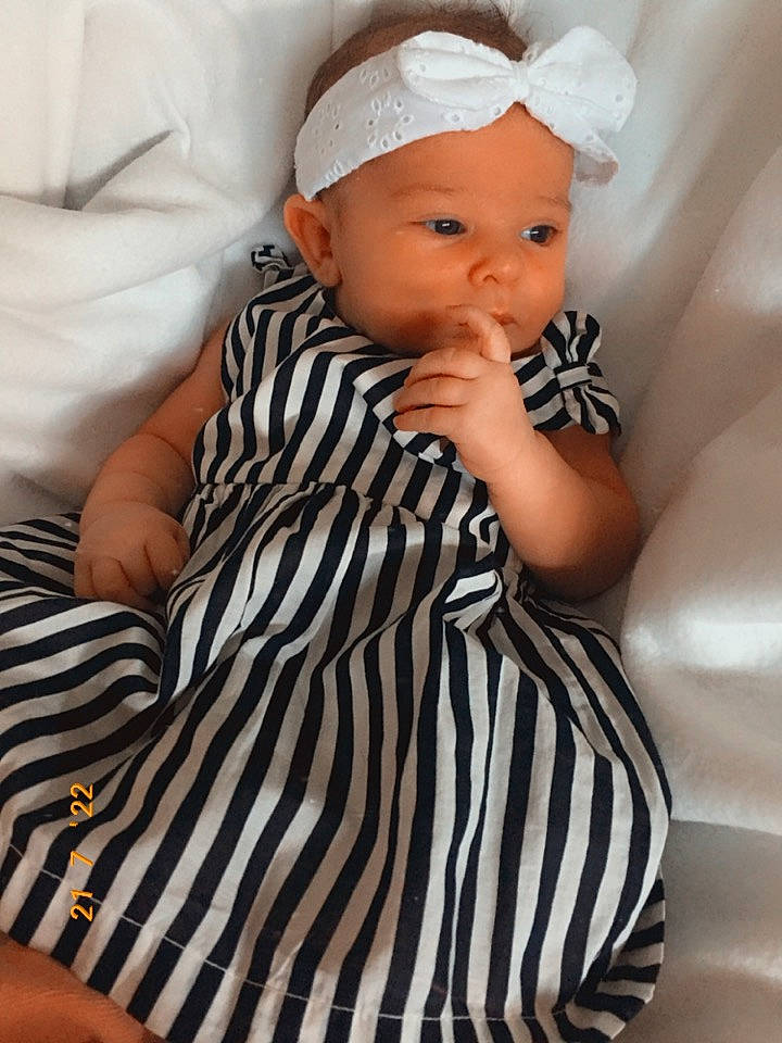 éna participe au concours pour gagner de l'argent avec cette photo : arm, baby, baby_toddler_clothing, cap, cheek, comfort, eyelash, face, hairstyle, hat, headgear, headwear, human_body, lip, neck, person, shoulder, sitting, skin, sleeve