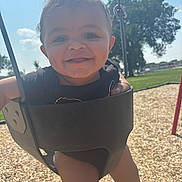 Jakai joined the competition — help win amazing prizes! baby, child, swing, playground, smiling, happy, outdoors, sunny, grass, wood_chips, tree, blue_sky, dimples, drool, black_clothing, barefoot, metal_chain, infant, fun, park