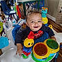 Jakai is registered to the contest to win money with this photo: baby, child, smiling, dimples, activity_center, toys, colorful, indoor, floor, table, chair, wood_floor, curtain, person, happy, infant, play, seat, face, young