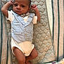 Legend is registered to the contest to win money with this photo: baby, infant, newborn, boy, clothing, vest, bow_tie, quilted_mat, blanket, lying_down, barefoot, indoors, baby_care, soft_texture, cute, person, face, small_hands, small_feet, portrait