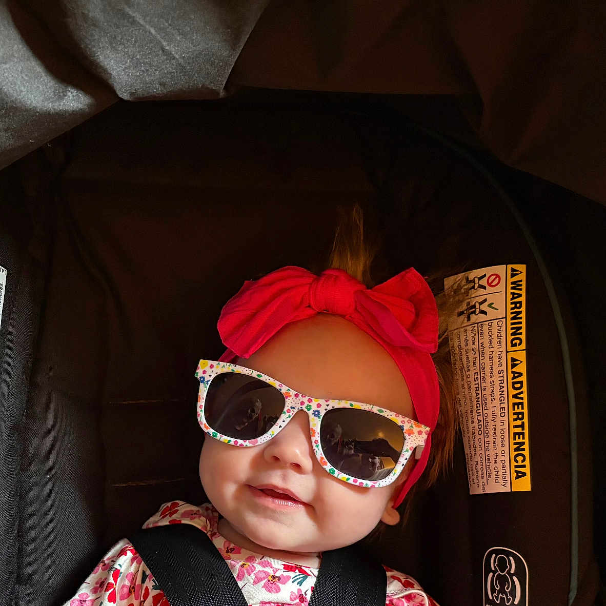 Jade Marie is registered to the contest to win money with this photo: accessory, adorable, baby, baby_girl, car_seat, child, clothing, cute, face, fashion, happy, headband, indoor, infant, person, portrait, seatbelt, smile, sunglasses, warning_label
